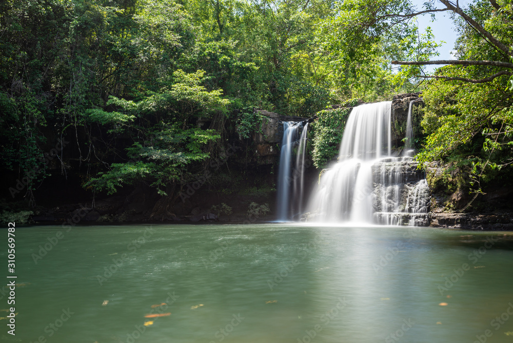 The waterfall in the hill behind a pond in jungle, long explosure technique photography The waterfall in the hill behind a pond in jungle, long explosure technique photography