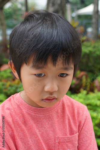 The Asian boy is upset and cry with tear drop at the park.