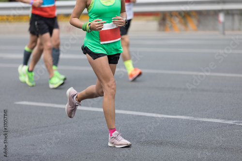 Marathon runners running on the race on city road © lzf