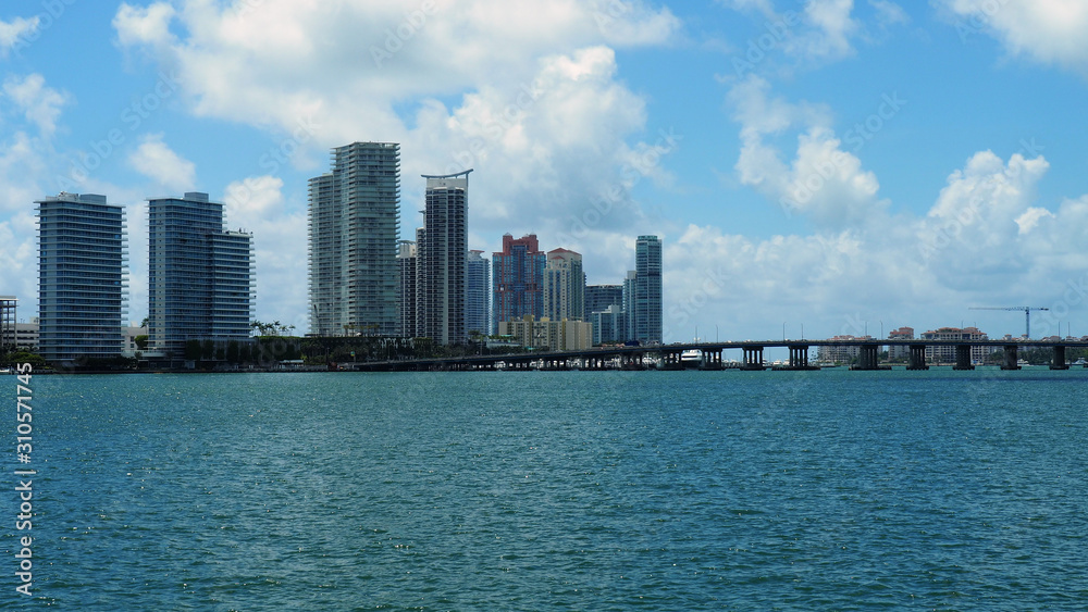 South beach skyline, Florida, multiple buildings on the horizon next to the sea, bridge crossing over water