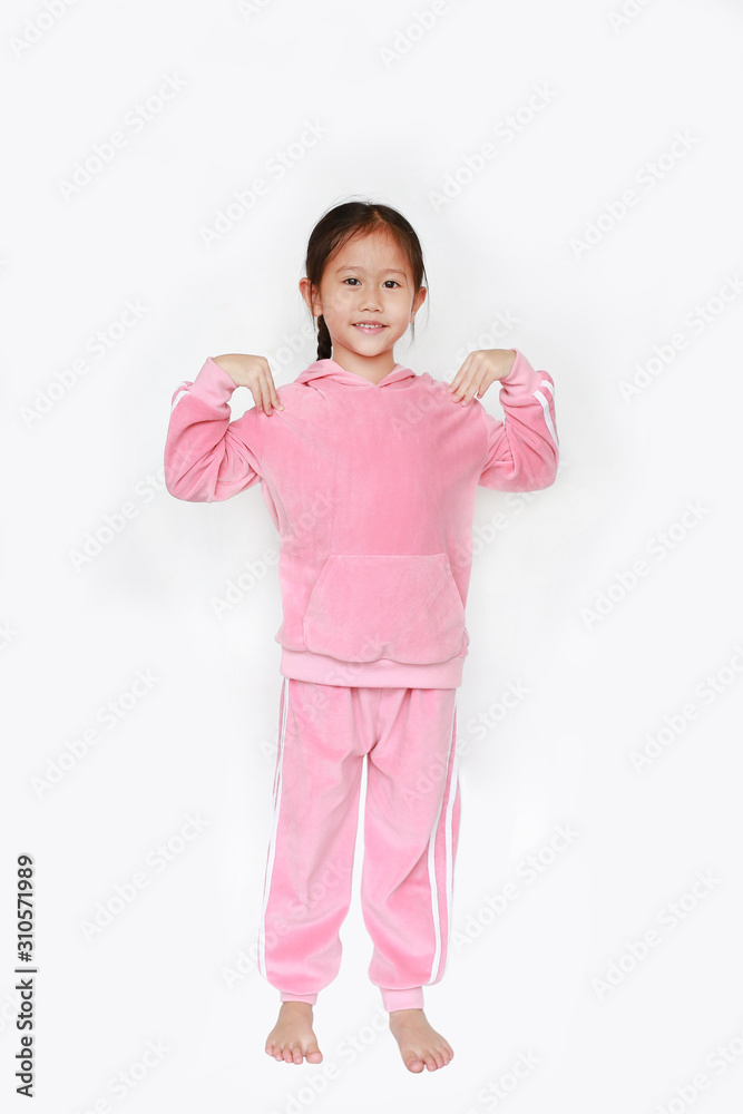 Adorable little Asian child girl in pink tracksuit or sport cloth doing exercises over white background. Adorable little Asian child girl in pink tracksuit or sport cloth doing exercises over white background.