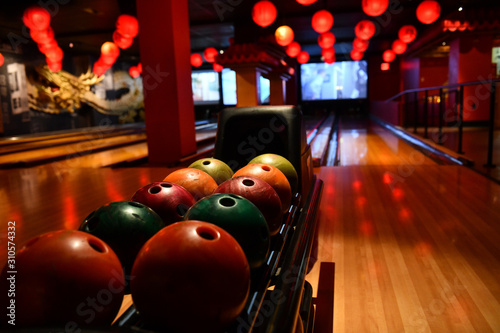 Bowling lane and balls in the row in bowling center. photo