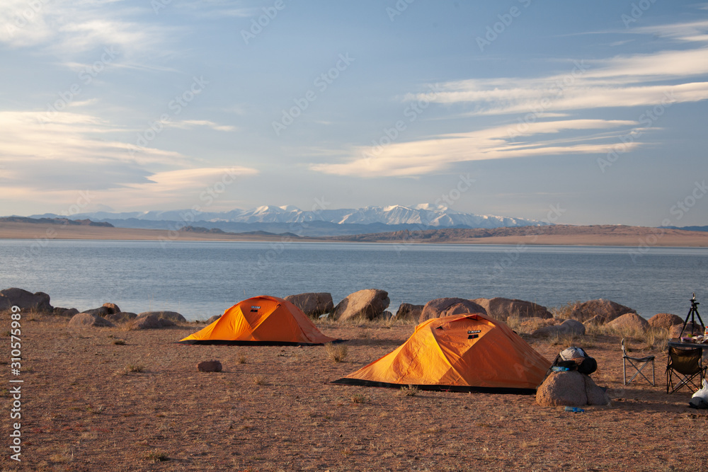 Cloudy view on a mountain lake. Mongolia tent on beach