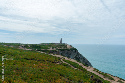 Monument with the cross on it at Cabo da Roca (Cape Roca) the westernmost  extent of mainland Portugal, continental Europe and the Eurasian land mass. Bright vivid landscape of European country. © D. Kvasnetskyy