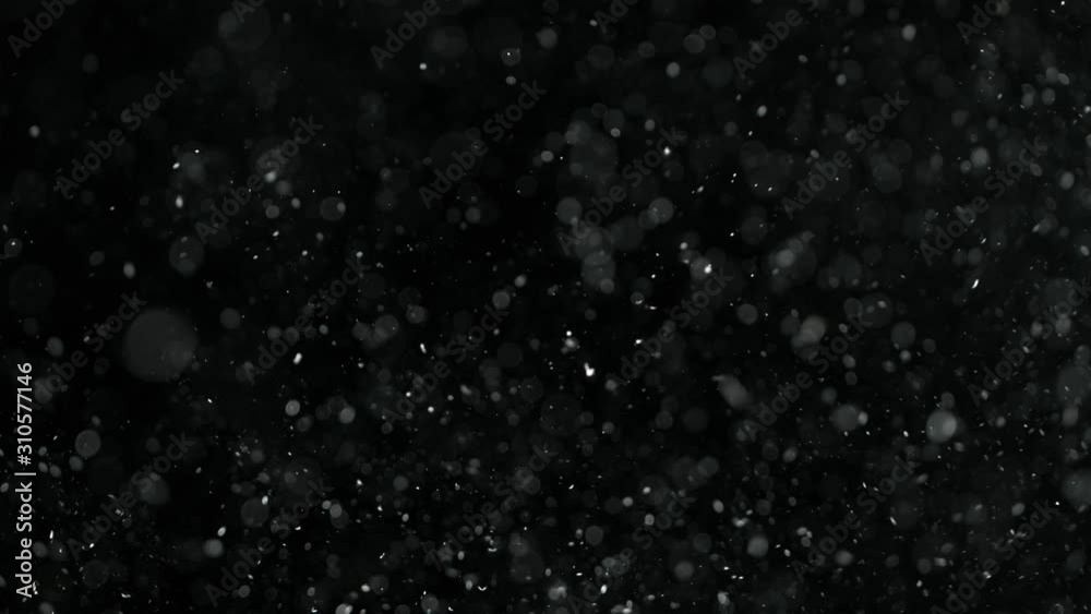 Natural organic dust particles on black background. Glittering Particles With Bokeh. Slow motion at 1000 fps.