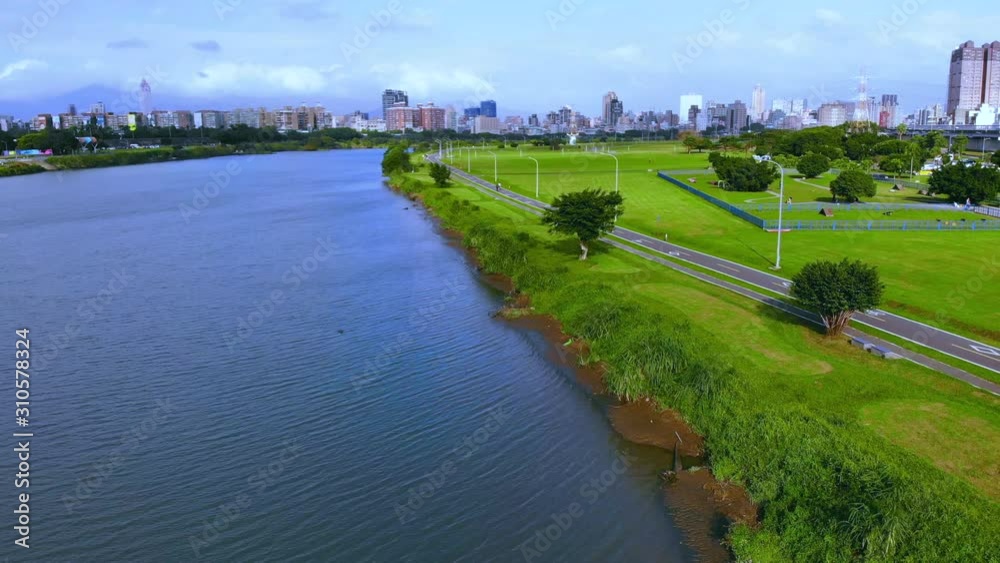 Aerial photo of Embankment Park in Taipei, Taiwan, blue sky, white clouds, trees, green grass, outdoor activities Aerial photo of Embankment Park in Taipei, Taiwan, blue sky, white clouds, trees, green grass, outdoor activities