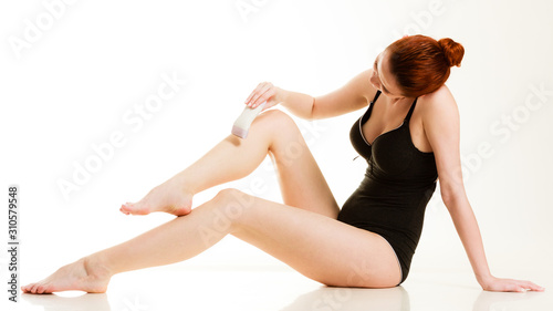Woman shaving her legs with electric razor