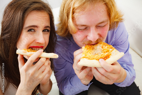 Funny couple eating pizza