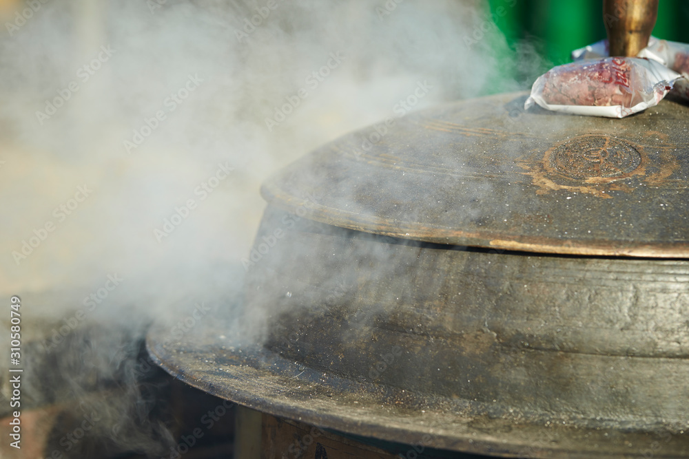 Steam coming out from traditional iron cooking pot Steam coming out from traditional iron cooking pot