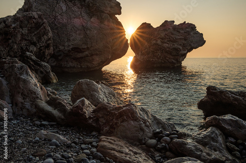 sun among the rocks on a rocky wild beach on the Mediterranean sea