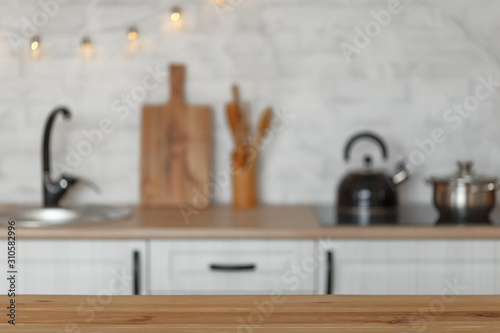 wooden table and blurry kitchen interior in the background. Preparation for design.