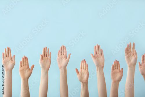 Hands of voting people on color background