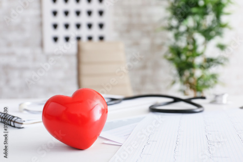 Cardiogram and heart on doctor's table. Cardiology concept