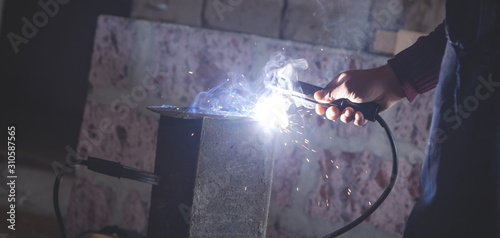 Welder performs welding work on metal. © andranik123