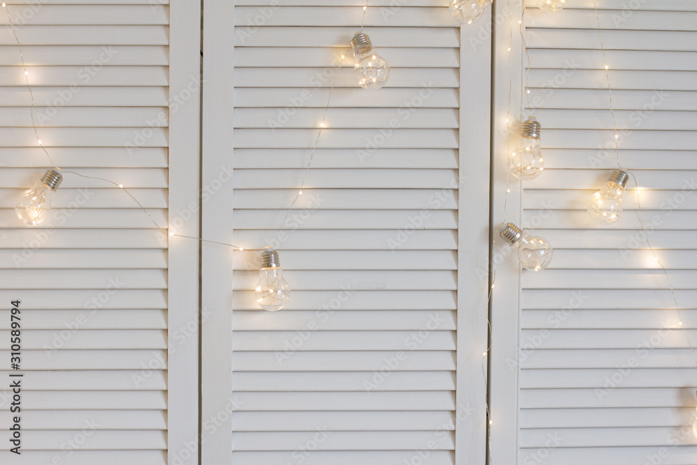 White background with a garland of light bulbs. background for your text. new year's interior. glitter and lights. the concept of the celebration. new year and Christmas. banner. White background with a garland of light bulbs. background for your text. new year's interior. glitter and lights. the concept of the celebration. new year and Christmas. banner.