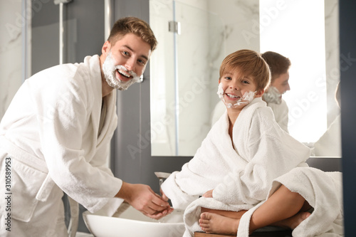 Dad and son washing hands in bathroom