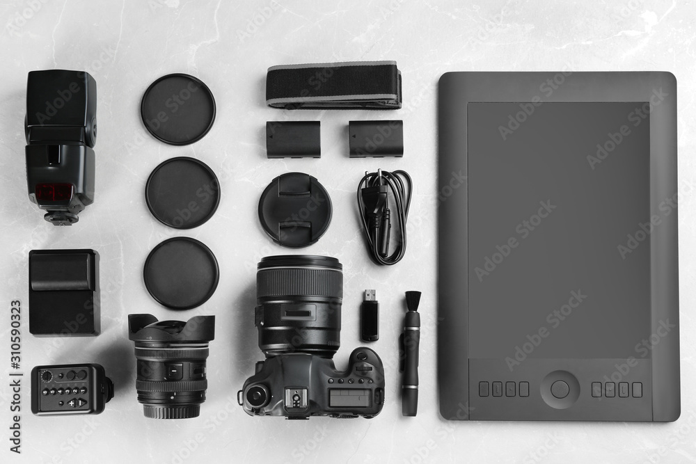 Flat lay composition with equipment for professional photographer on grey marble table