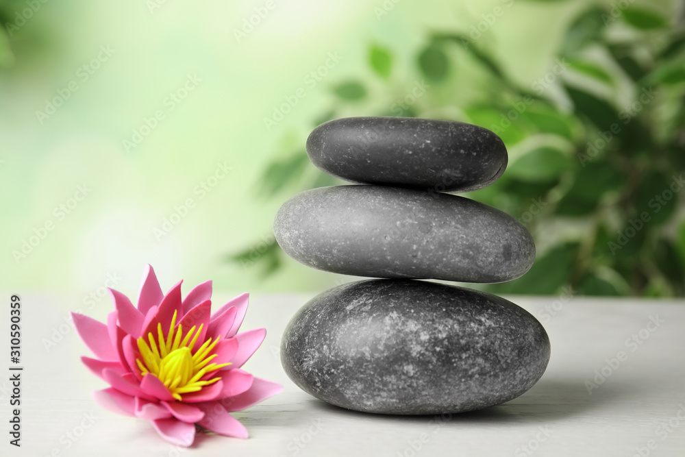 Zen lifestyle. Beautiful lotus flower and stones on white wooden table  Stock Photo | Adobe Stock