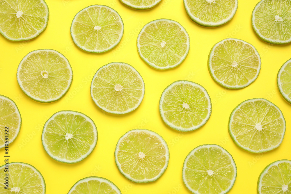 Fresh juicy lime slices on yellow background, flat lay