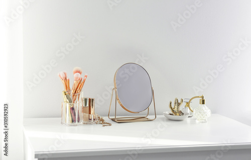 Canvas-taulu Small mirror and makeup products on white dressing table indoors