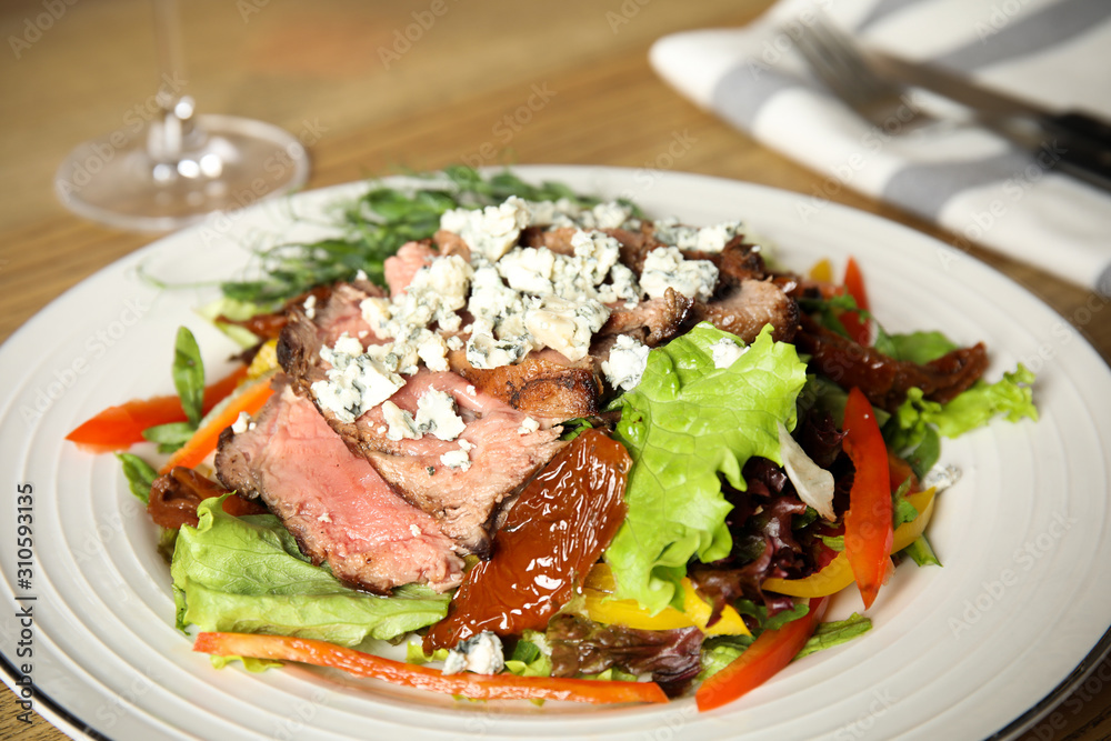 Delicious salad with roasted meat and vegetables served on table, closeup Delicious salad with roasted meat and vegetables served on table, closeup