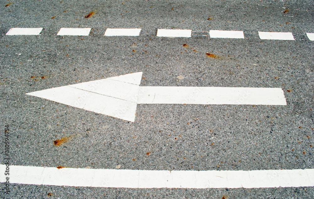 Fototapeta premium white arrow sign on asphalt road