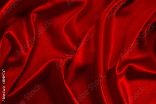 Red silk or satin luxury fabric texture can use as abstract background. Top view.