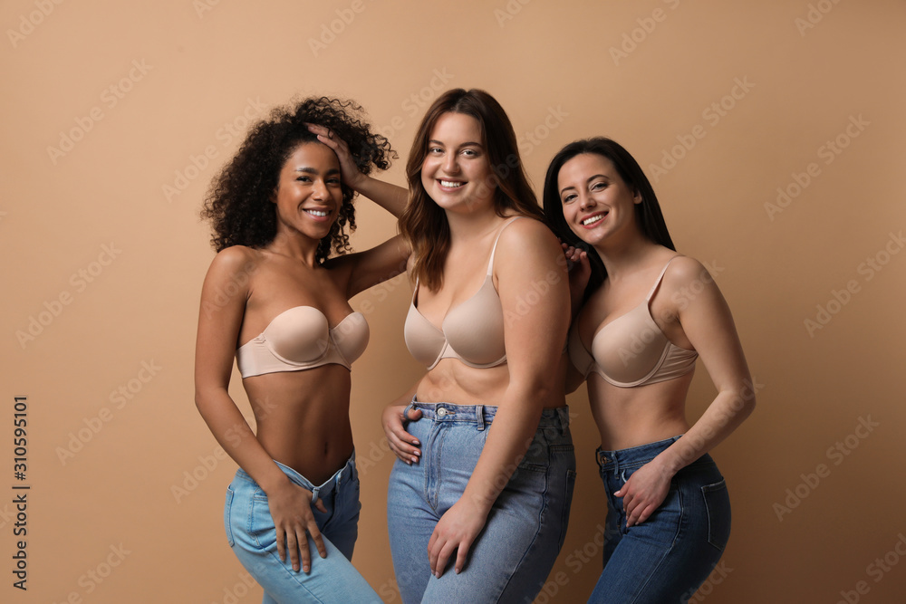 Foto Stock Group of women with different body types in jeans and underwear  on beige background | Adobe Stock