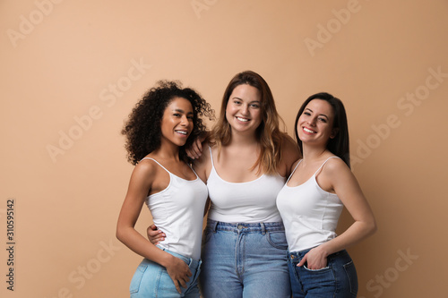 Group of women with different body types on beige background