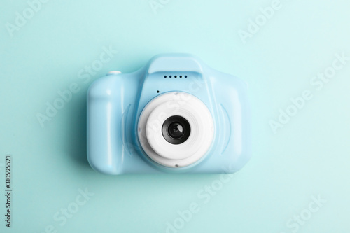 Toy camera on light blue background, top view. Future photographer