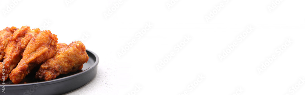 Close up to Korean fried chicken wings isolated on a white background in studio with copy space. Close up to Korean fried chicken wings isolated on a white background in studio with copy space.