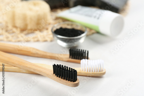 Bamboo toothbrushes on white table  closeup. Space for text