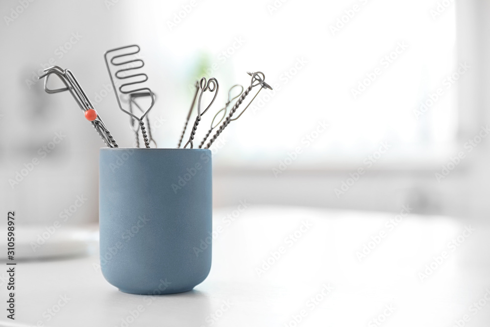 Set of different logopedic probes in holder on light table, space for text. Speech therapist's tools Set of different logopedic probes in holder on light table, space for text. Speech therapist's tools