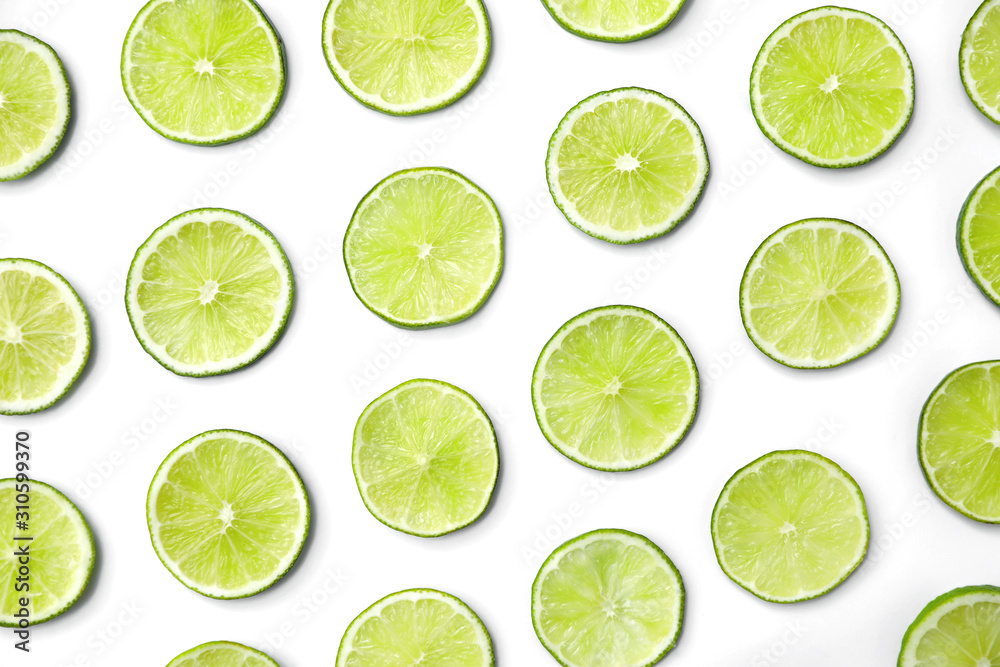Slices of fresh juicy limes on white background, flat lay