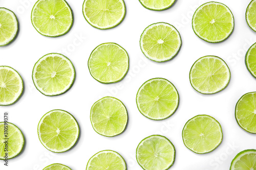 Slices of fresh juicy limes on white background, flat lay