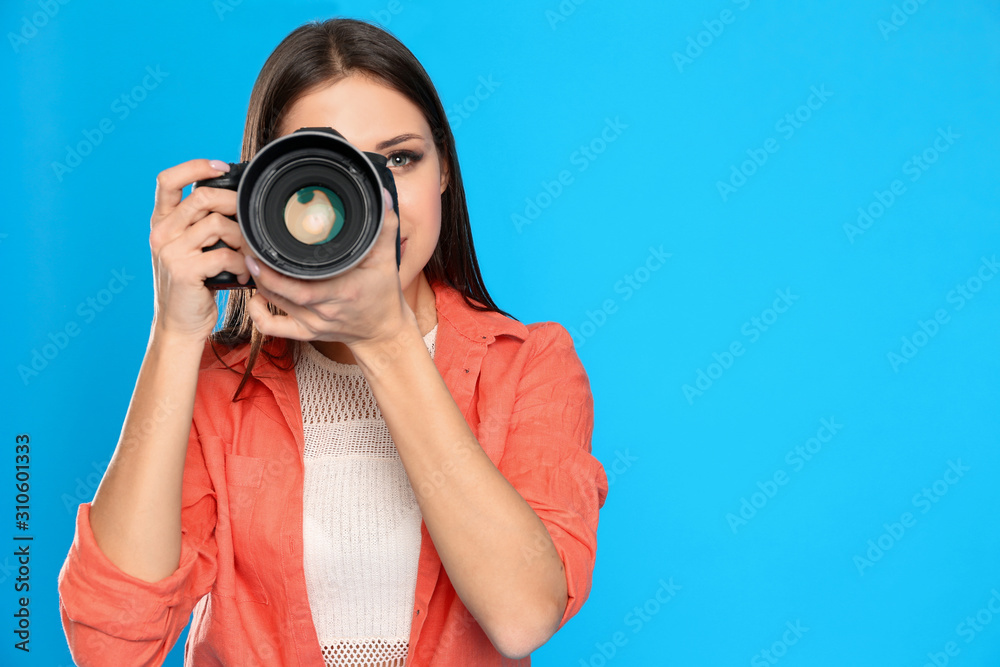 Professional photographer working on light blue background in studio. Space for text Professional photographer working on light blue background in studio. Space for text