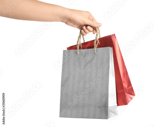 Woman holding paper shopping bags on white background, closeup. Space for design