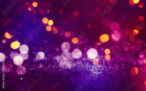 Hearts on a sparkling shiny background. Red abstract background. Blurry bokeh, neon light.