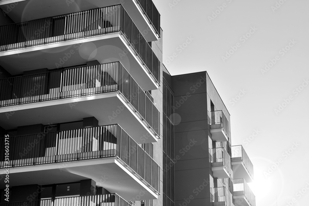 Sun rays light effects on urban buildings. Fragment of modern residential apartment with flat buildings exterior. Detail of new luxury house and home complex. Black and white. Sun rays light effects on urban buildings. Fragment of modern residential apartment with flat buildings exterior. Detail of new luxury house and home complex. Black and white.