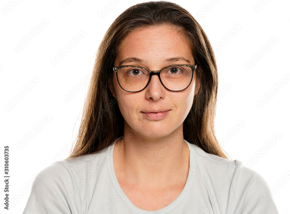 Portrait of young smiling woman with glasses and  without makeup on white background