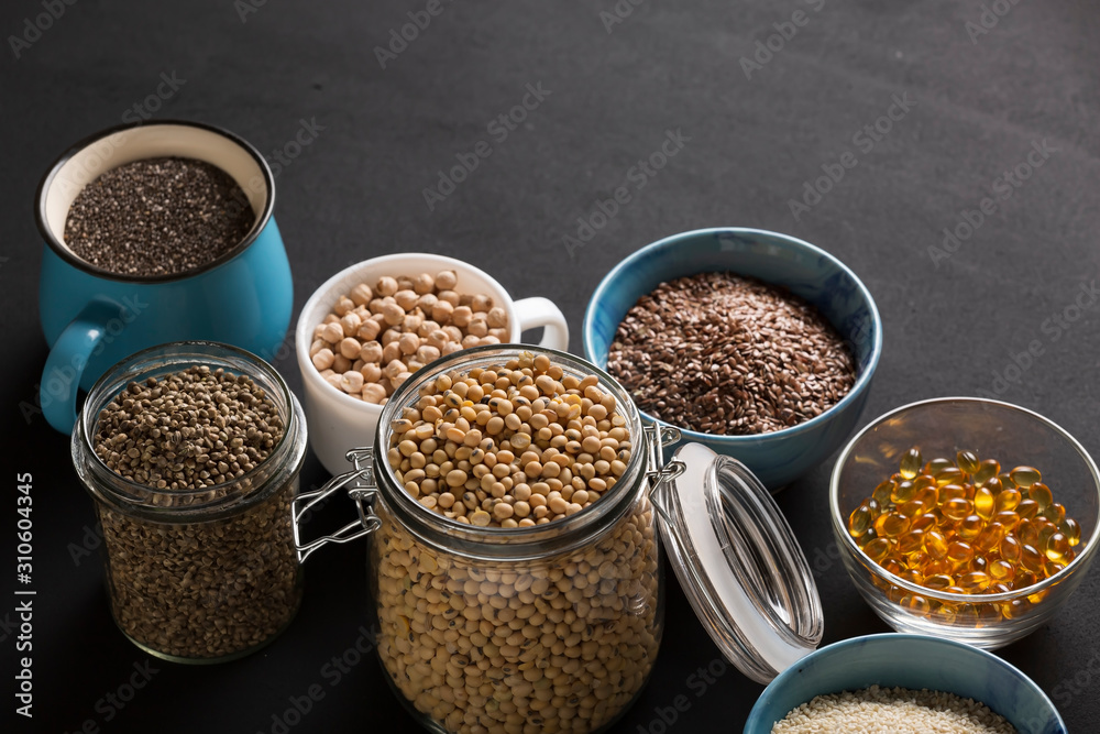 Food background. Various seeds and grains- Source of omega 3 foods. Fish oil, chickpeas, soybeans, hemp seeds, chia, sesame seeds, flax seeds. Omega 3 background.