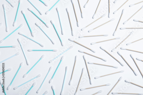 Plastic and wooden cotton swabs on white background, top view. Recycling concept