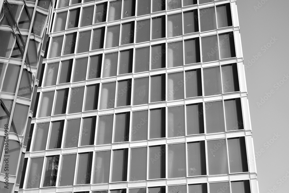 Sun rays light effects on urban buildings in sunset. Modern office building detail, glass surface with sunlight. Business background. Black and white. Sun rays light effects on urban buildings in sunset. Modern office building detail, glass surface with sunlight. Business background. Black and white.