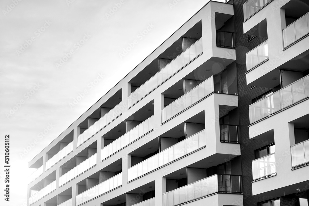 Sun rays light effects on urban buildings. Fragment of modern residential apartment with flat buildings exterior. Detail of new luxury house and home complex. Black and white. Sun rays light effects on urban buildings. Fragment of modern residential apartment with flat buildings exterior. Detail of new luxury house and home complex. Black and white.