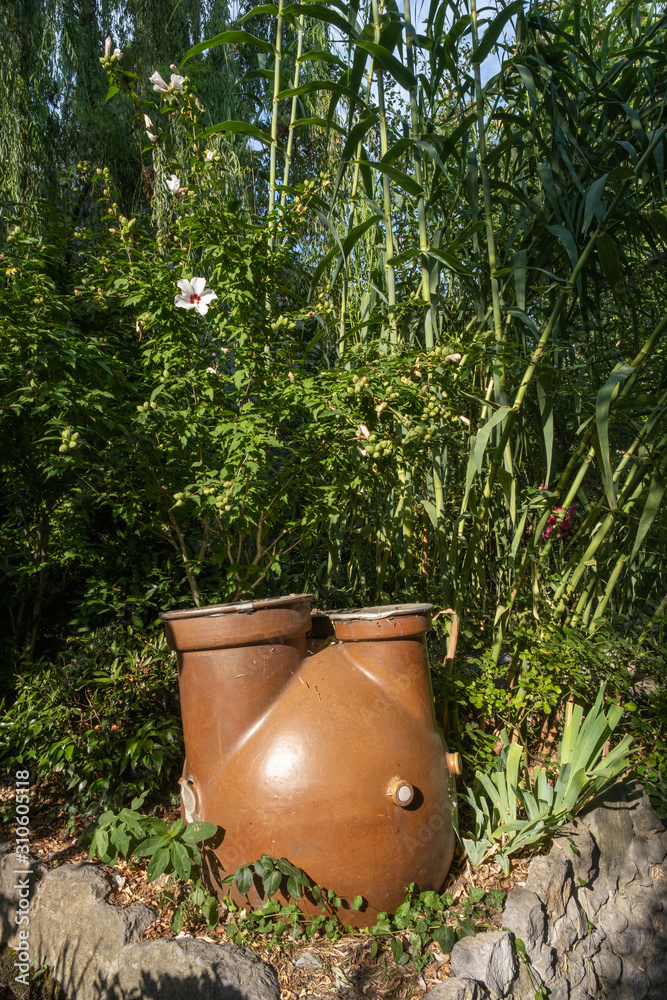 A large clay vessel for collecting water and watering plants.