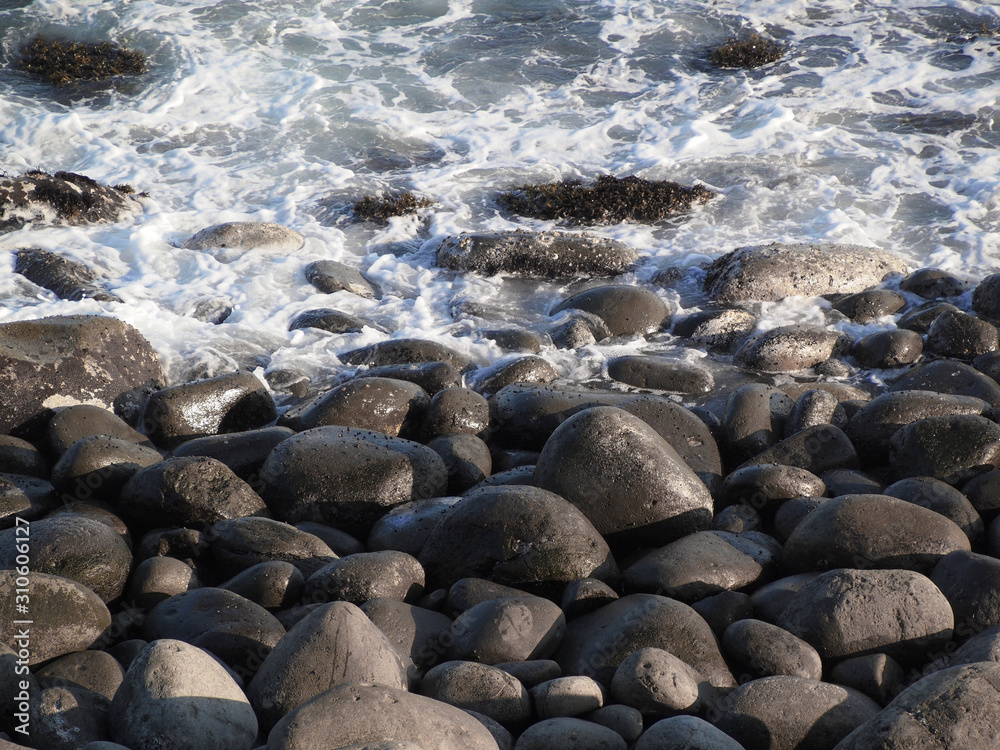 Coastal landscape with lots of large round stones eroded by waves Coastal landscape with lots of large round stones eroded by waves