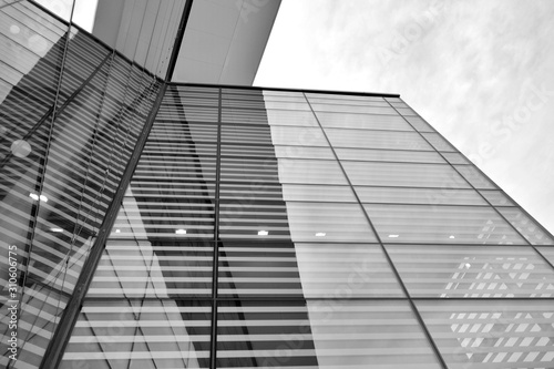 Sun rays light effects on urban buildings in sunset. Modern office building detail, glass surface with sunlight. Business background. Black and white.