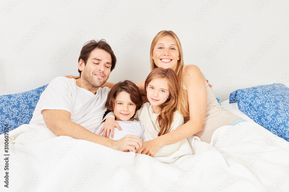 Happy young parents and two kids in bed Happy young parents and two kids in bed