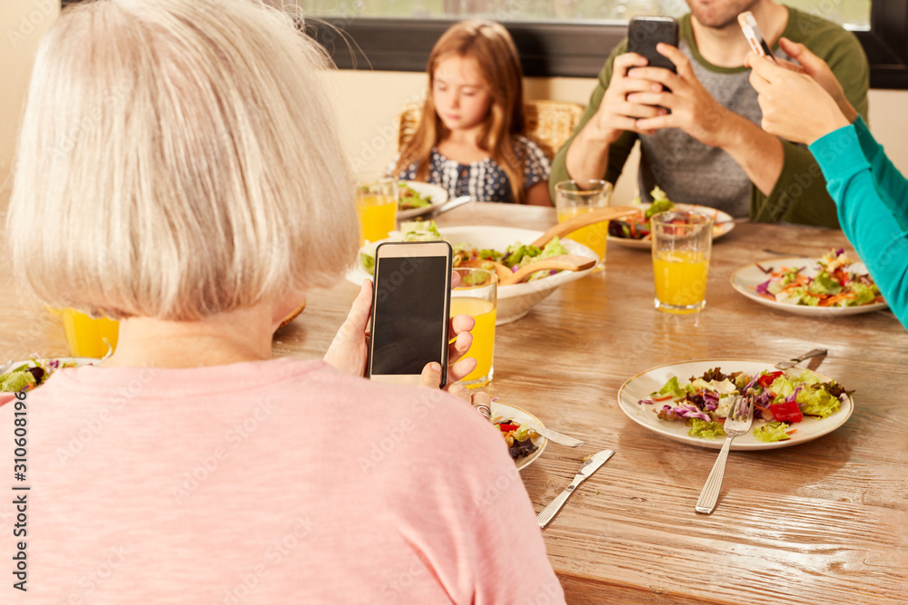 Family having dinner with smartphone and mobile phone Stock Photo ...