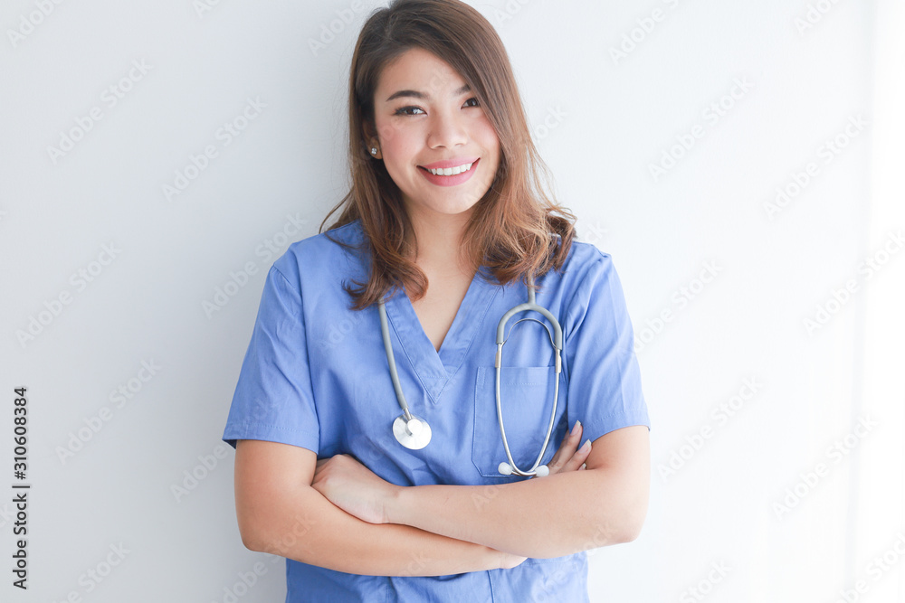 Asian woman in blue doctor uniform using telephone on white background Asian woman in blue doctor uniform using telephone on white background
